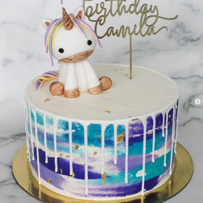 Watercolor birthday cake with fondant unicorn topper and white drip