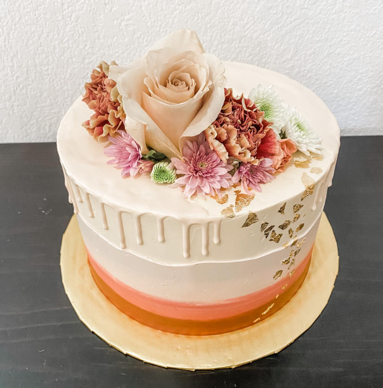 Coral ombré drip cake crowned with fresh roses and chrysanthemums