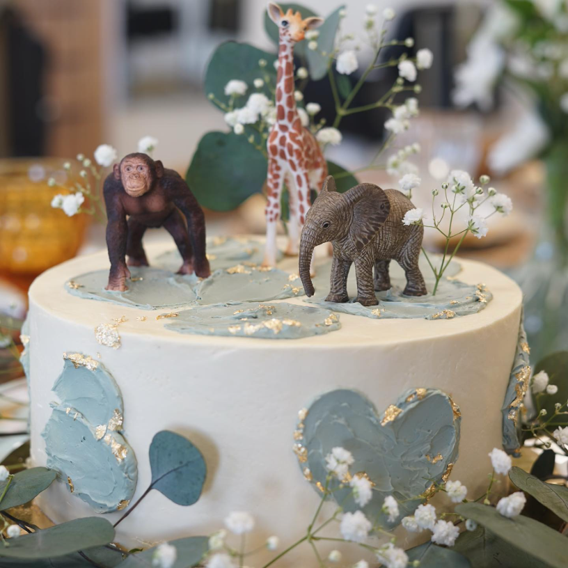 Ivory safari cake with sage buttercream texture, gold leaf and animal toppers